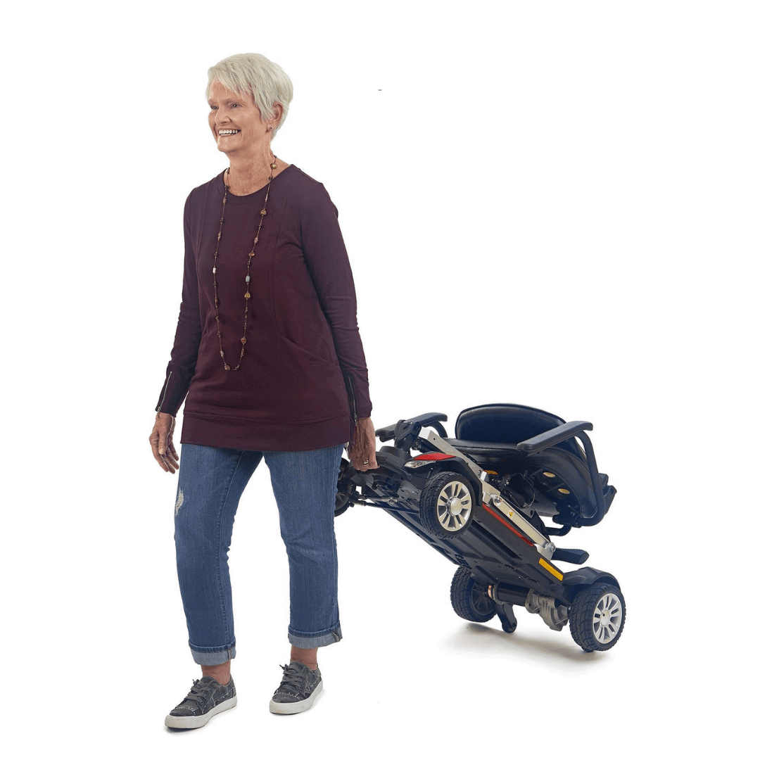Golden Tech Buzzaround Carry-On Folding Travel Scooter with Travel Battery being transported by patient