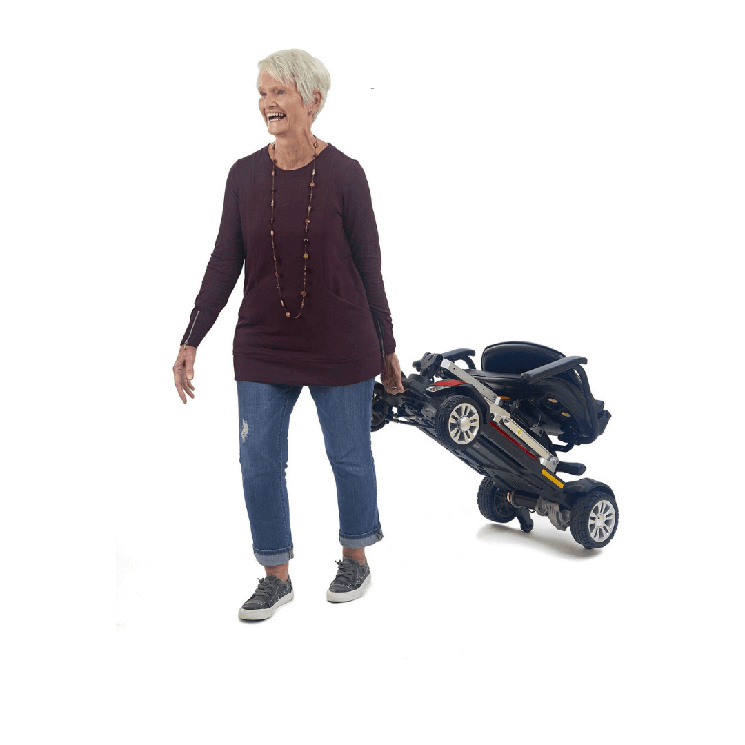 Golden Tech Buzzaround Carry-On Folding Travel Scooter with Travel Battery being transported by patient 3