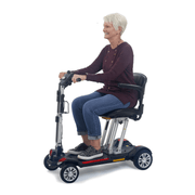 Golden Tech Buzzaround Carry-On Folding Travel Scooter with Travel Battery being transported by patient