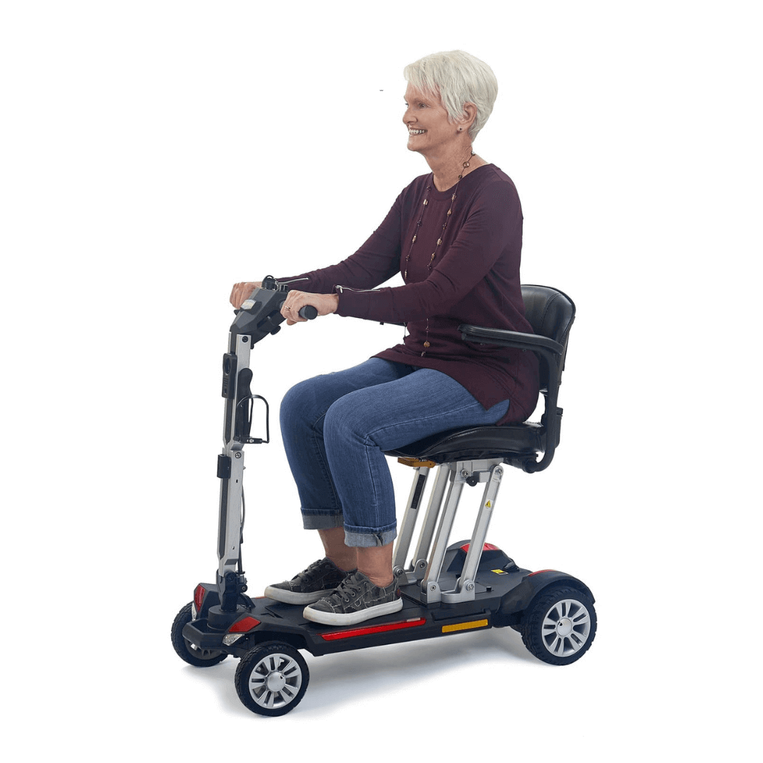 Golden Tech Buzzaround Carry-On Folding Travel Scooter with Travel Battery being transported by patient