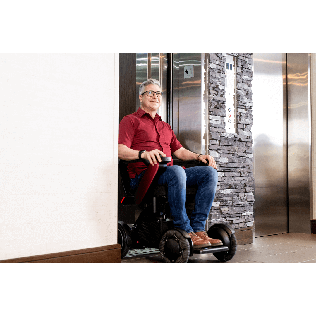 Whill C2 Premium Power Chair with patient going out of the elevator